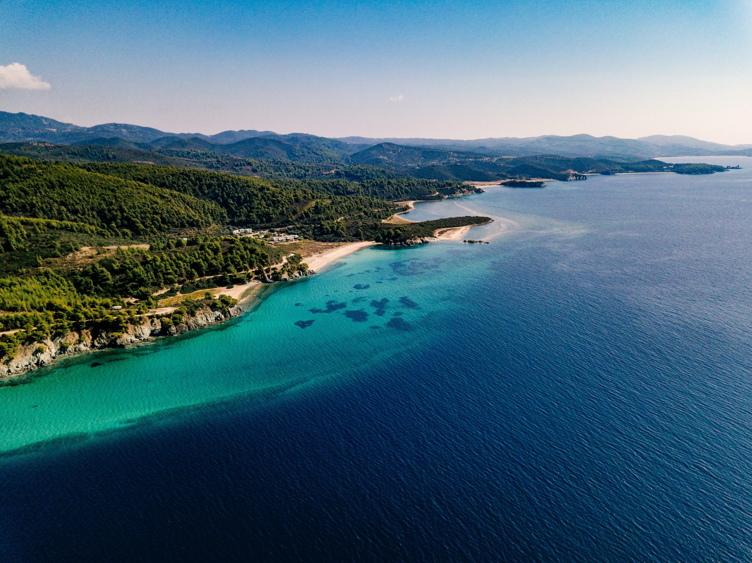 aerial-view-rocks-turquoise-sea-lagoon-greece-scaled
